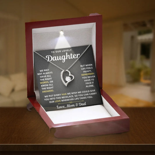 To Our Daughter Forever Love necklace from Mom & Dad in a lit mahogany gift box on a wooden table